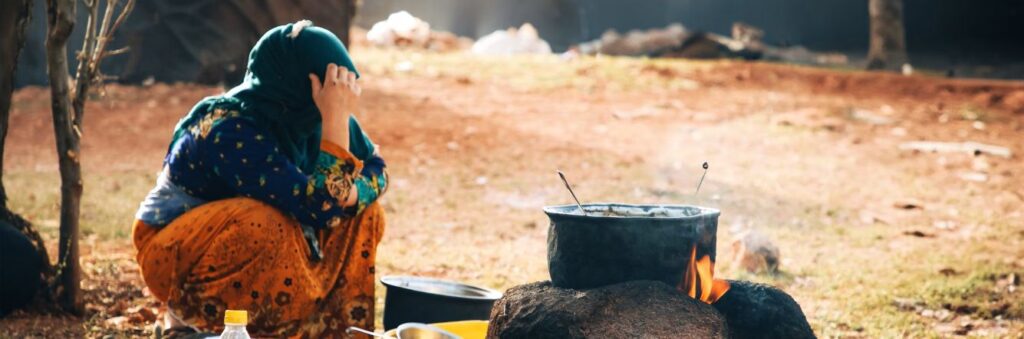 displaced woman in a field cooking